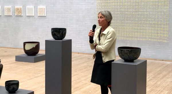 fynske-kunsthaandvaerkere-fernisering03 Kvinde præsenterer keramik